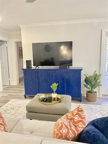 a living room with a blue entertainment center with a flat screen tv at 8th Floor Stylish Downtown Condo Private Balcony in Atlanta
