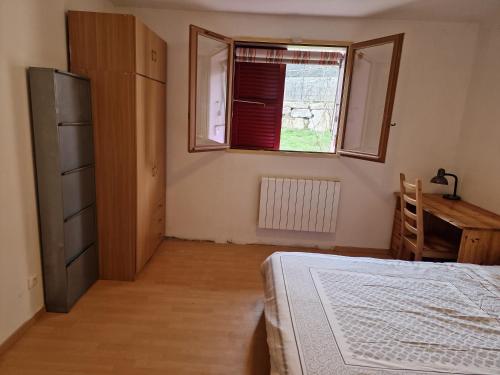 ein Schlafzimmer mit einem Bett, einem Fenster und einem Schreibtisch in der Unterkunft Maison près de Genève, CERN, et stations de ski in Péron