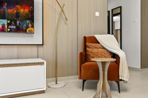 a living room with a chair and a lamp at Desert Key - Platinum Apartments in Gate Tower, Al Reem Island in Abu Dhabi