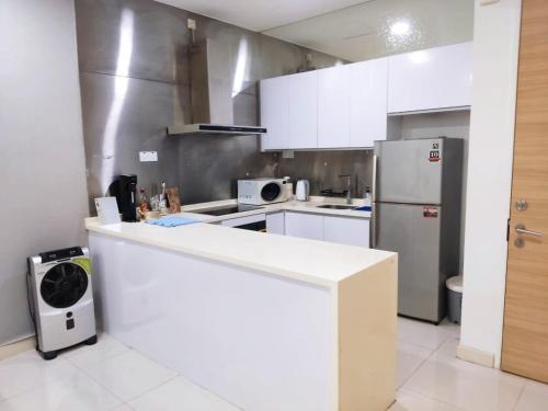 a kitchen with a white counter and a refrigerator at Camellia Serviced Suites in Kuala Lumpur