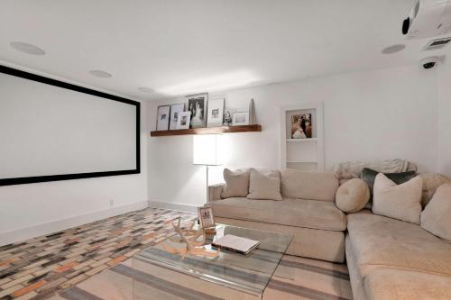 a living room with a couch and a large screen at Wilson Park Spa home sauna and walking trails in Fayetteville