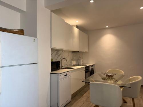 a kitchen with a white refrigerator and a table and chairs at Loft Story in Lisbon Humberto Delgado Airport