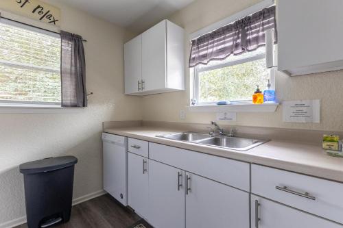 a kitchen with white cabinets and a sink and a window at Air Haus LITE in Fourth Crossing