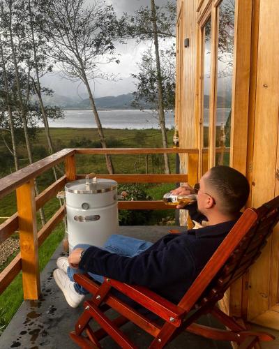 a man sitting in a rocking chair on a porch at Villa De Los Sueños in Pasto