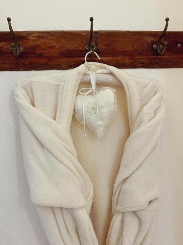 a white sweater hanging on a wooden rack at Pousada Recanto da Família in Natal