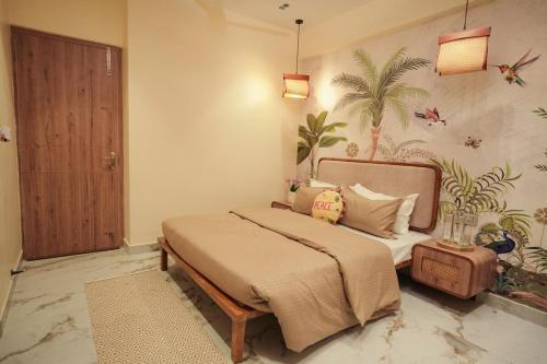 a bedroom with a bed and a palm tree mural at The Nomads Escape in Siliguri