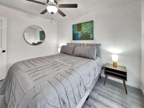 a bedroom with a large bed with a ceiling fan at Razorback Retreat- 5 mi to University of Arkansas in Fayetteville