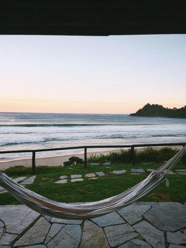 a hammock overlooking a beach with the ocean at Hosteria CASA MILLER B&B FRENTE AL MAR in Bahía Mansa