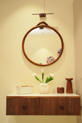 a mirror on top of a counter with a vase at The Nomads Escape in Siliguri
