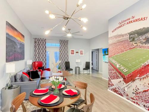 un salon avec une fresque de match de football sur le mur dans l'établissement Stay at Steuben Hot Tub Remodeled Home, à Springdale