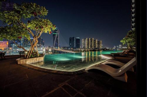 una piscina con vistas a la ciudad por la noche en Metropole Saigon Luxury Residence, en Ho Chi Minh