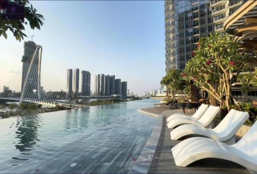 Un río en una ciudad con sillas y edificios blancos. en Metropole Saigon Luxury Residence, en Ho Chi Minh