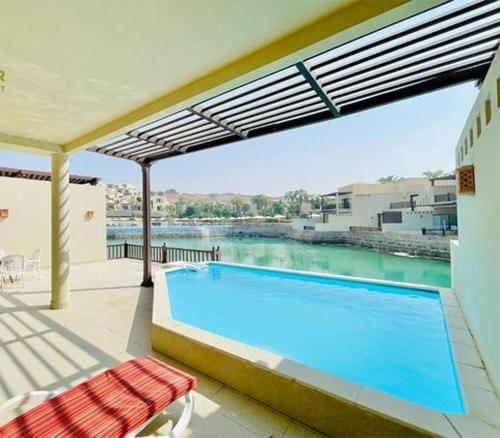 a swimming pool with a view of the water at Exclusive 2BR Poolside Villa 5 Star Resort Escape in Ras al Khaimah