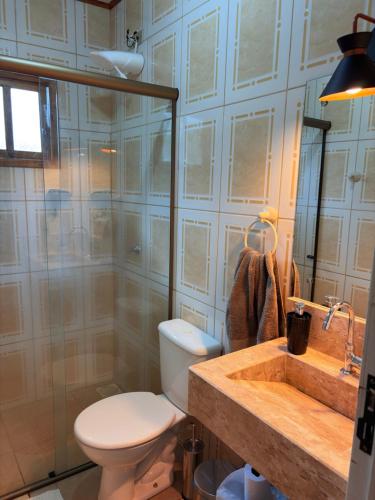 a bathroom with a toilet and a sink at Casa da Serra borrussia in Osório