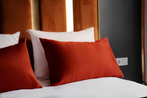 a bed with red and white pillows and a window at Crown Taksim Hotel in Istanbul