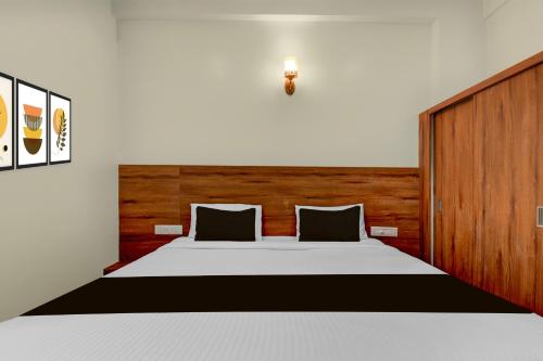 Un dormitorio con una cama grande con cabecero de madera. en Hotel O Royal Stay, en Hirisāve