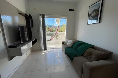 a living room with a couch and a television at Apartamento em Pomerode Centro - Térreo in Pomerode