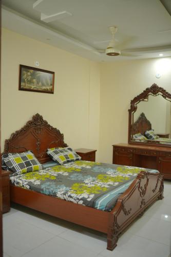 a bedroom with a large bed and a mirror at Moon Residence in Karachi