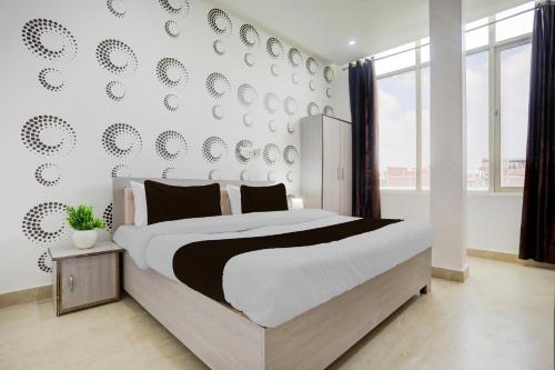 a bedroom with a large bed and a wall with plates at Hotel O Samridhi Inn in Varanasi