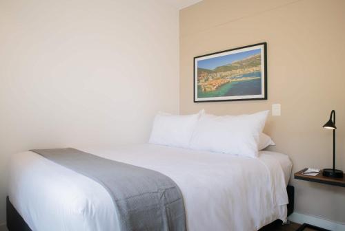 a hotel room with a white bed and a picture on the wall at Seaside Studio 1BR near the Malecon in Miraflores in Lima