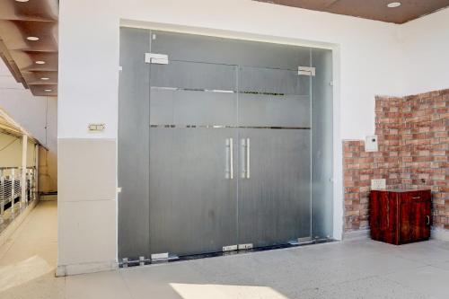a large metal door in a room with a brick wall at Hotel O THE PRAVAHA in Noida
