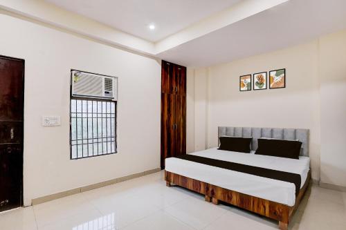 a bedroom with a bed and a window at Hotel O The Great Royal Hotel in Indirapuram