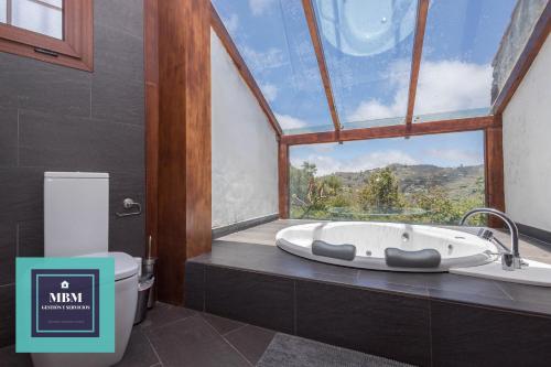a bathroom with a large window and a bath tub at Casa Brumas de Arbejales in Teror