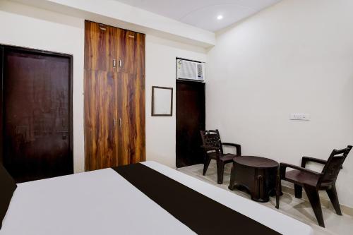 a bedroom with a bed and two chairs and a table at Hotel O The Great Royal Hotel in Indirapuram