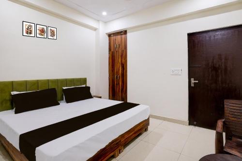 a bedroom with a bed and a wooden door at Hotel O The Great Royal Hotel in Indirapuram