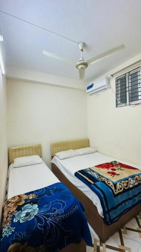 a room with two beds and a ceiling at Hotel Tulip Residence in Dhaka