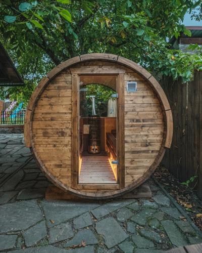 a circular wooden hobbit house with a wooden door at Apartmán V medvědím brlohu in Dolní Lomná