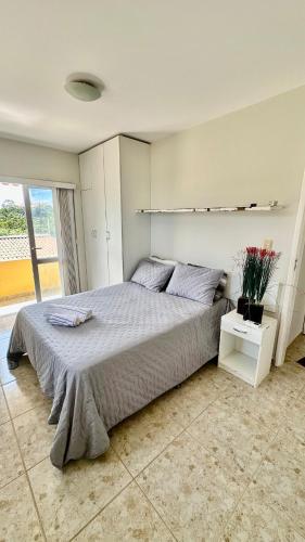 a bedroom with a large bed and a large window at Elaine Graziela in Pitimbu