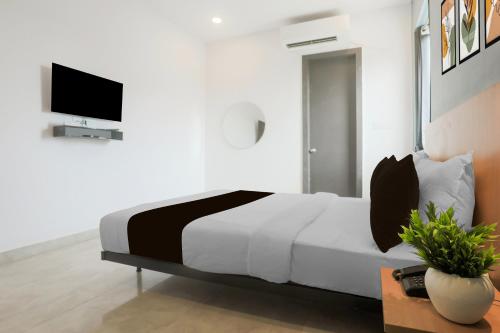 a bedroom with a bed and a tv on a wall at Hotel O Vivek inn Palace in Prayagraj