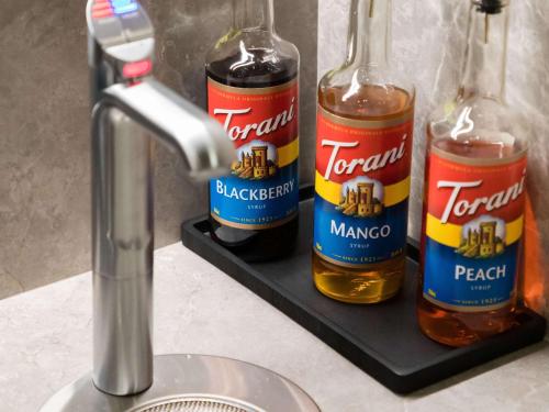 two bottles of beer on a shelf next to a sink at Hotel Stratford San Francisco - Handwritten Collection in San Francisco
