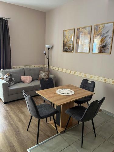 a living room with a couch and a table and chairs at Solaris Apartman in Zalakaros
