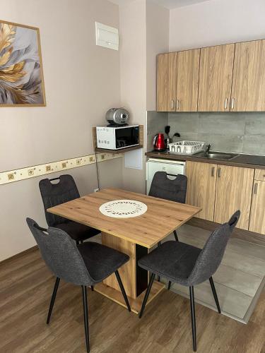 a kitchen with a wooden table and chairs at Solaris Apartman in Zalakaros