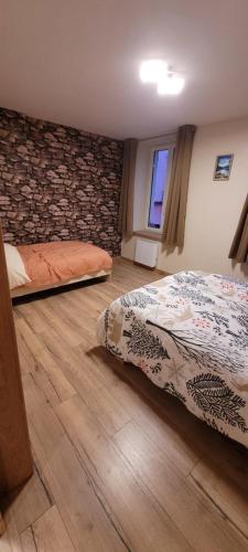 una camera da letto con due letti e un muro di pietra di Appartement 49m2 hyper centre a Gérardmer