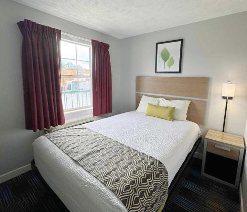 a hotel room with a bed and a window at Mountain Aire Inn Sevierville - Pigeon Forge in Sevierville