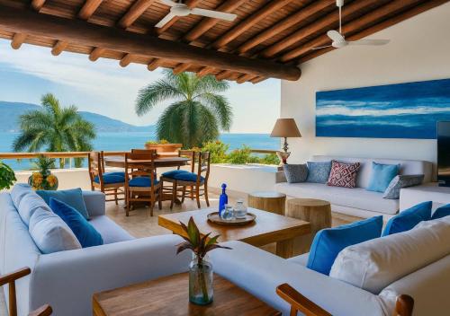 a living room with white couches and a table at Oceanfront Villa w Private Jacuzzi & Club Access in Ixtapa