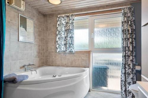a bathroom with a tub and a window at SJ310-Hejls-Ronnebaervaenget-14 in Hejls