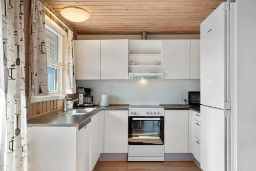 a kitchen with white cabinets and a sink and a stove at SJ310-Hejls-Ronnebaervaenget-14 in Hejls