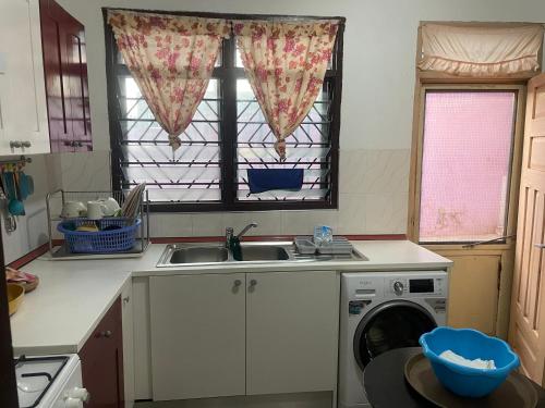 a kitchen with a sink and a washing machine at West link guest house in Gbawe