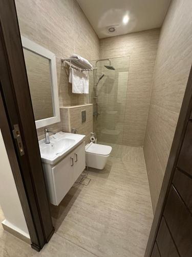 a bathroom with a sink and a toilet and a shower at Midtown Lweibdeh Hostel in Amman