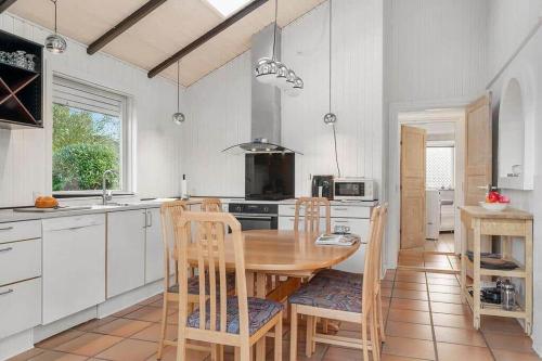 a kitchen with a wooden table and chairs in it at SJ311-Hejls-Slaenvaenget-9 in Hejlsminde