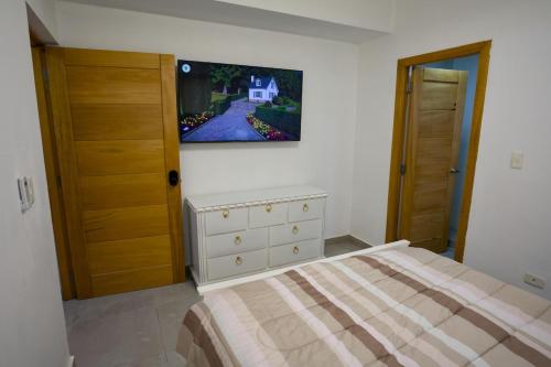a bedroom with a bed and a dresser at Amazing 2BR apartment near the airport in Los Frailes