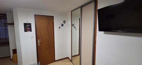 a room with a flat screen tv and a door at Résidence des Touristes in Pierrefitte-Nestalas