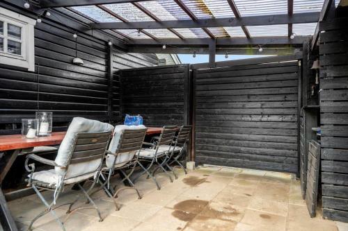 a table and chairs in a room with a black wall at 30120-Malling-Fjordvej-11 in Norsminde