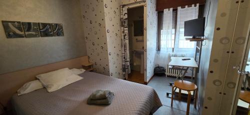 a bedroom with a bed and a desk and a television at Résidence des Touristes in Pierrefitte-Nestalas