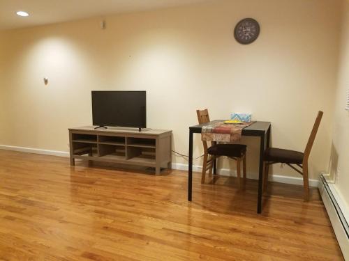 a living room with a tv and a table with chairs at Cozy1B1B W Private Entrance in Jericho