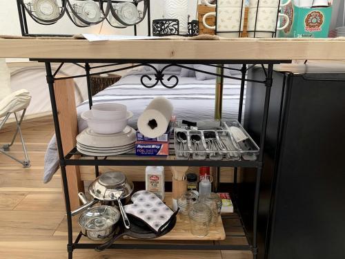 a shelf with dishes and other items on it at A Truly Glamping Experience in this Beautiful Tent in Victor, West Virginia in Victor